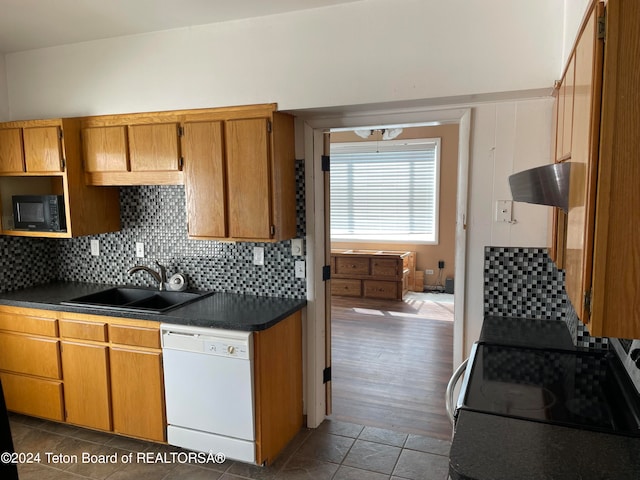 kitchen featuring tasteful backsplash, dishwasher, sink, dark tile patterned flooring, and electric range