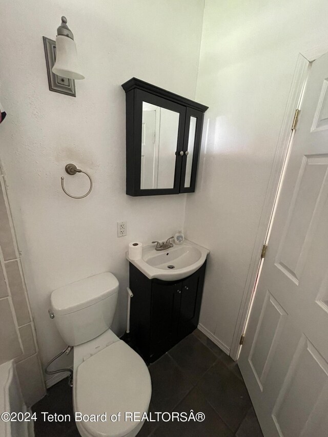 bathroom with tile patterned flooring, vanity, and toilet