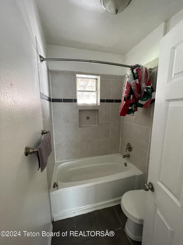 bathroom with tiled shower / bath combo and toilet