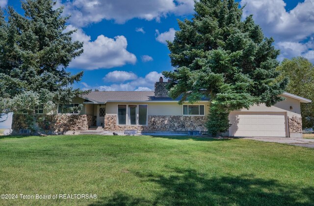 ranch-style house with a garage and a front lawn