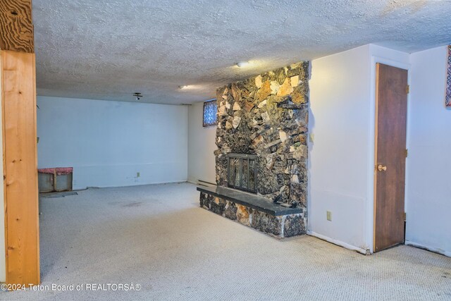 unfurnished living room featuring a fireplace, a textured ceiling, and carpet floors