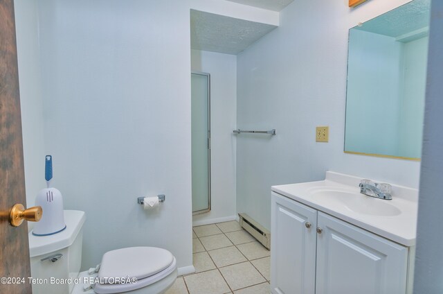 bathroom featuring tile patterned flooring, toilet, a baseboard radiator, vanity, and a textured ceiling