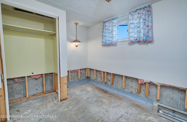 unfurnished bedroom featuring a textured ceiling and a closet