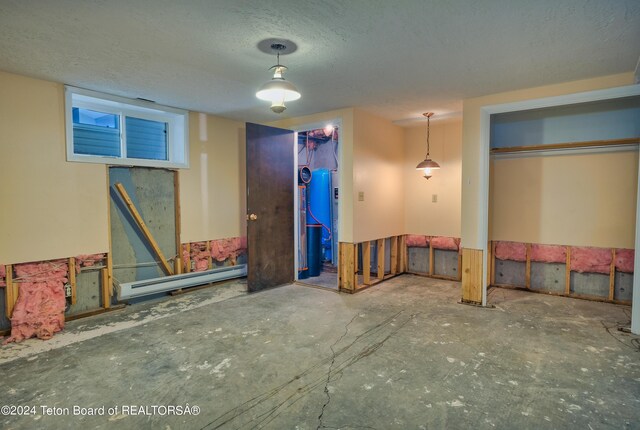 interior space with a textured ceiling, a baseboard heating unit, and a closet