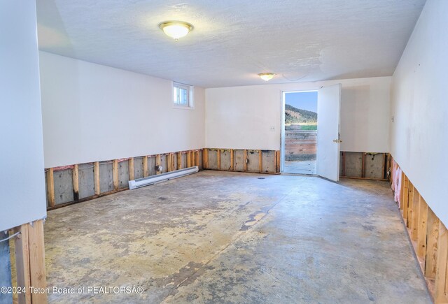 unfurnished room with a textured ceiling and a baseboard radiator