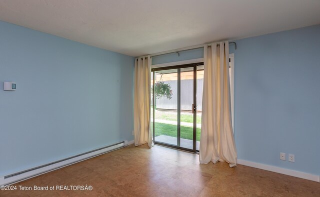 spare room featuring a wealth of natural light, tile patterned flooring, and baseboard heating