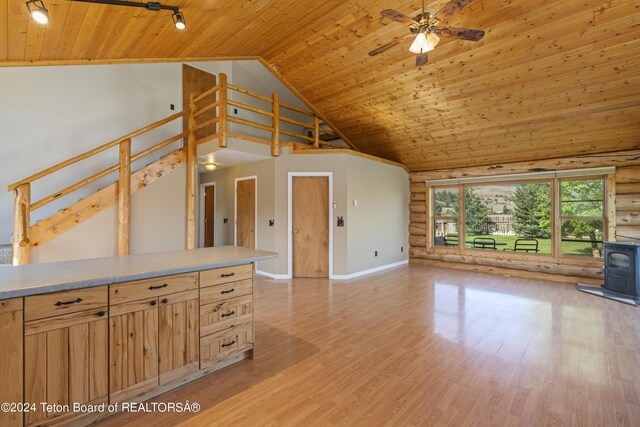 unfurnished living room featuring ceiling fan, light hardwood / wood-style flooring, wood ceiling, and a wood stove