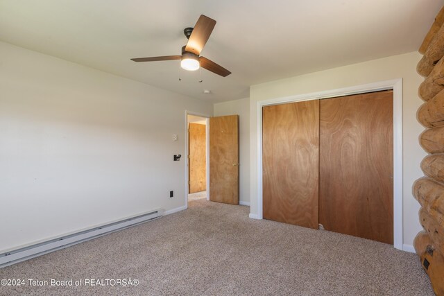 unfurnished bedroom featuring carpet floors, a baseboard radiator, a closet, and ceiling fan