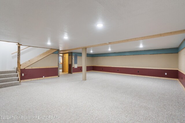 basement with carpet and a textured ceiling