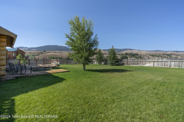 view of yard with a deck with mountain view