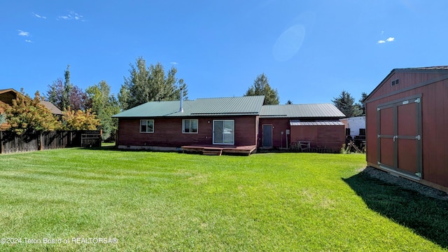 rear view of house with a shed and a yard