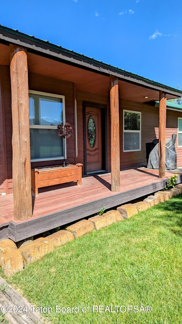 doorway to property with a wooden deck and a yard