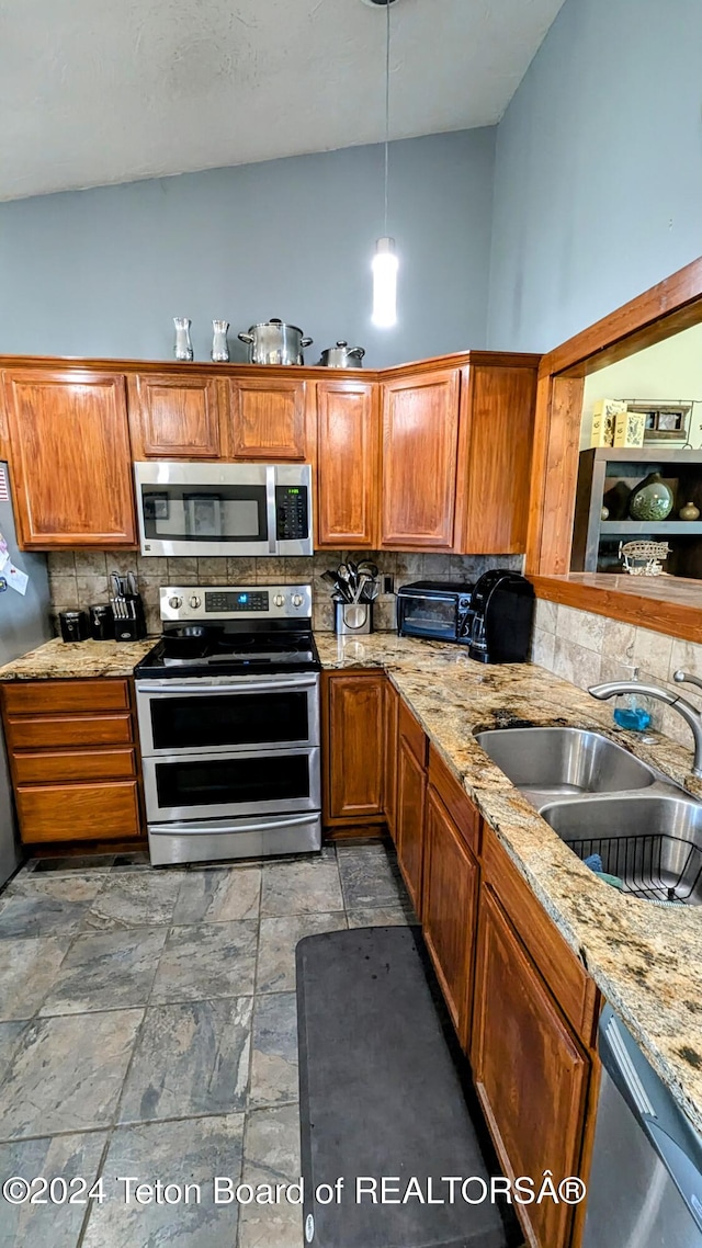 kitchen featuring appliances with stainless steel finishes, tasteful backsplash, sink, light stone counters, and high vaulted ceiling