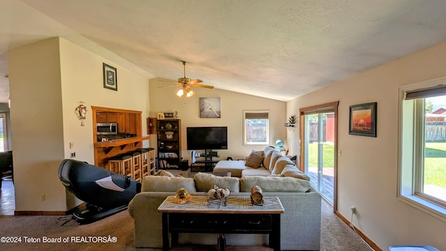 carpeted living room featuring ceiling fan, plenty of natural light, and lofted ceiling