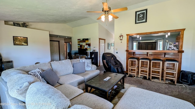 carpeted living room with ceiling fan and vaulted ceiling