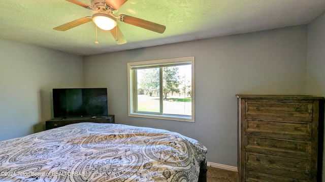 bedroom with ceiling fan, carpet, and a textured ceiling