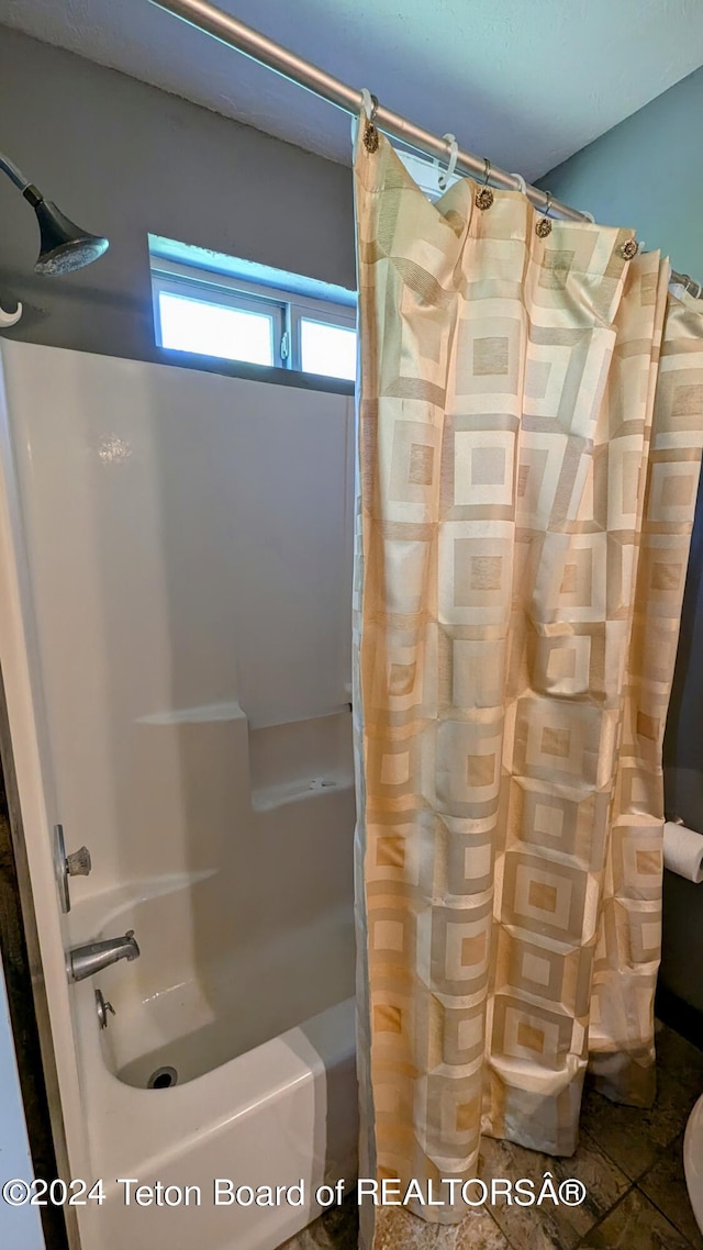 bathroom with shower / bath combo with shower curtain and tile patterned floors