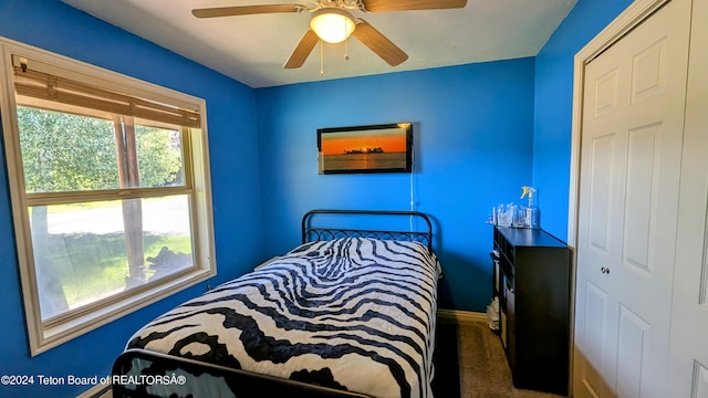 carpeted bedroom with ceiling fan and a closet