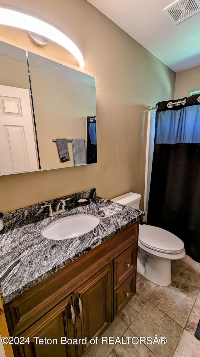 bathroom featuring tile patterned floors, toilet, and vanity