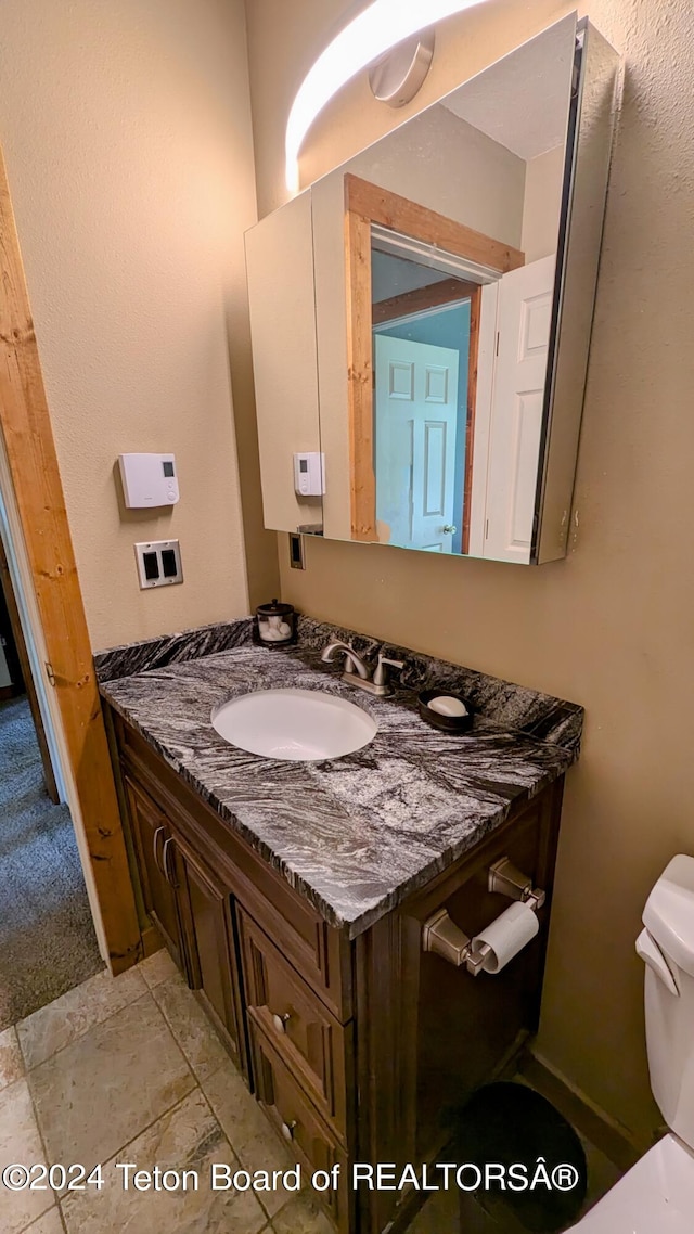 bathroom featuring tile patterned floors, vanity, and toilet