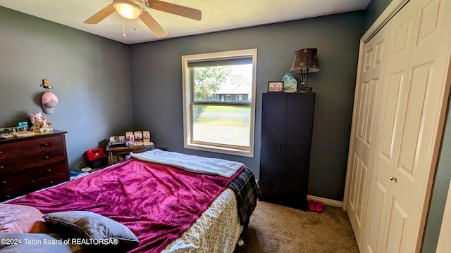 carpeted bedroom with ceiling fan and a closet