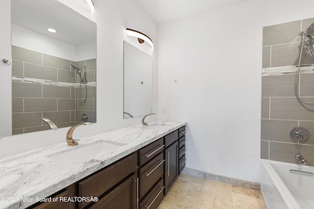 full bathroom with double vanity, bathtub / shower combination, a sink, and baseboards