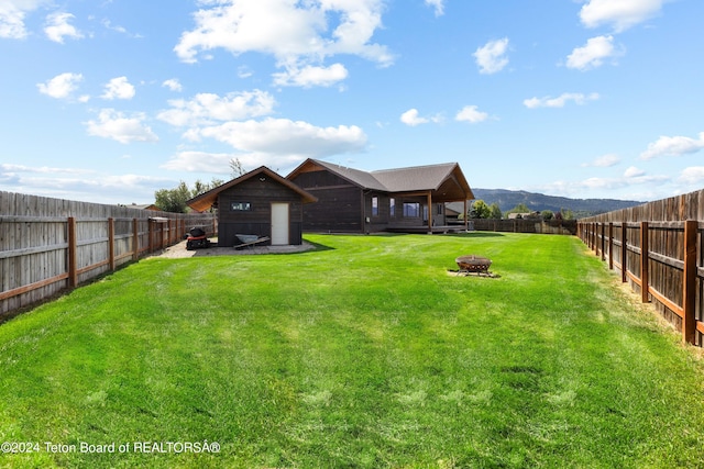 view of yard with a fenced backyard and a fire pit