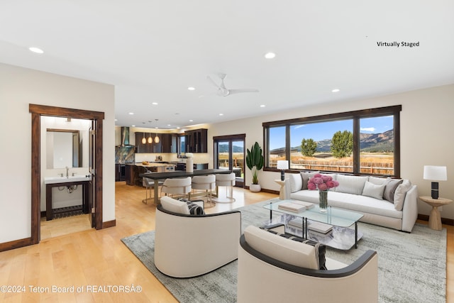 living area with baseboards, light wood-style flooring, and recessed lighting