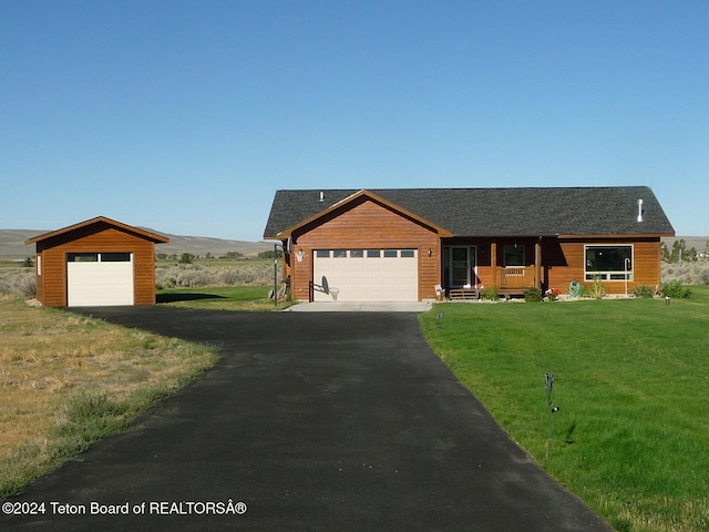 view of front of home with a mountain view, a front lawn, covered porch, and a garage