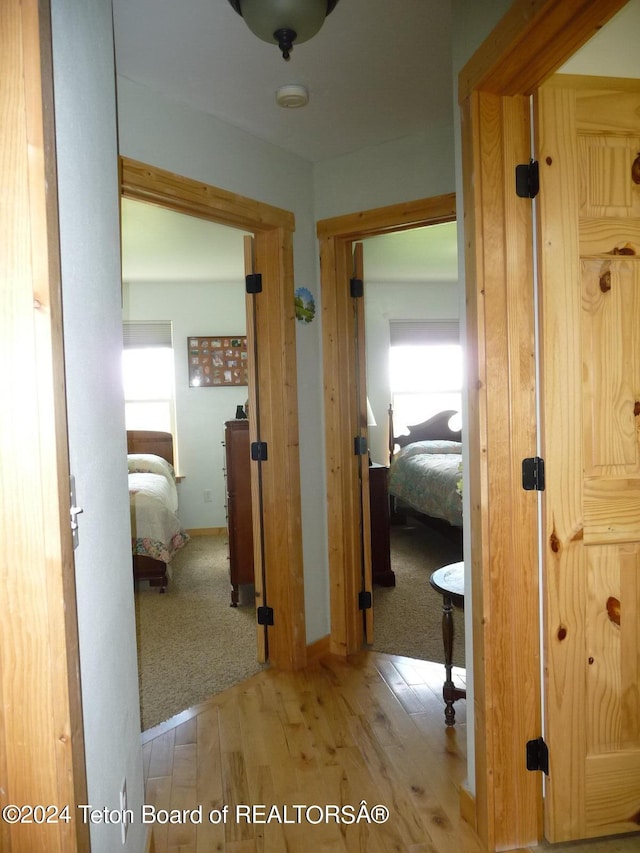 hallway with light wood-style flooring and baseboards