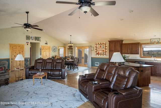 living area featuring vaulted ceiling, ceiling fan, light wood finished floors, and visible vents