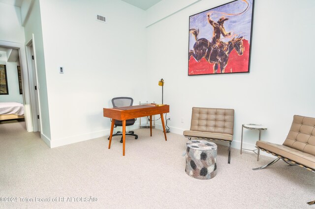 living area featuring baseboards, visible vents, and carpet