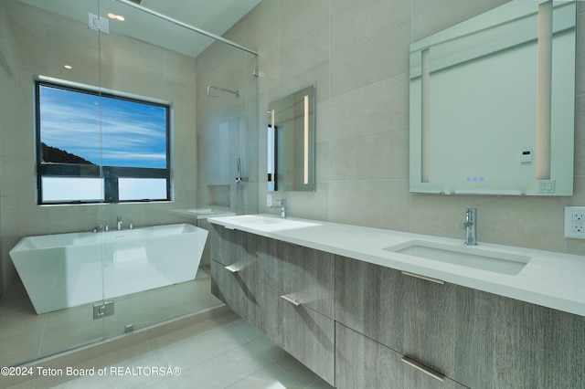 bathroom with double vanity, a sink, tile patterned flooring, and a freestanding bath