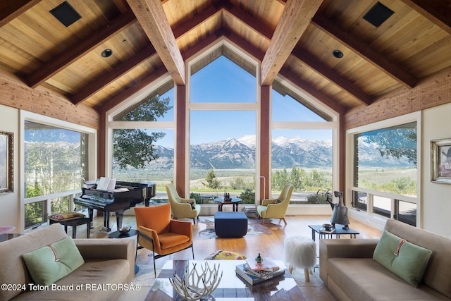 sunroom / solarium featuring a mountain view, lofted ceiling with beams, and wooden ceiling