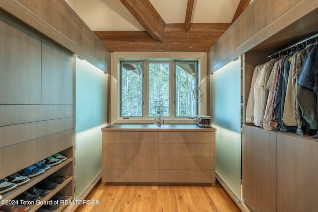 spacious closet with beam ceiling and light hardwood / wood-style floors