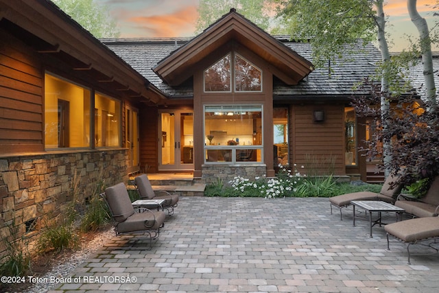 back house at dusk with a patio