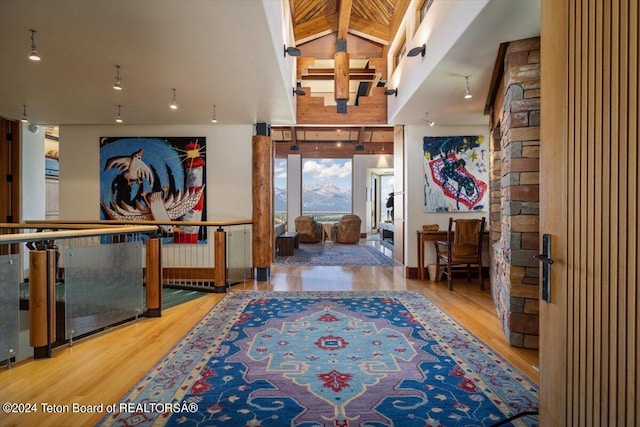 foyer entrance with hardwood / wood-style floors and high vaulted ceiling