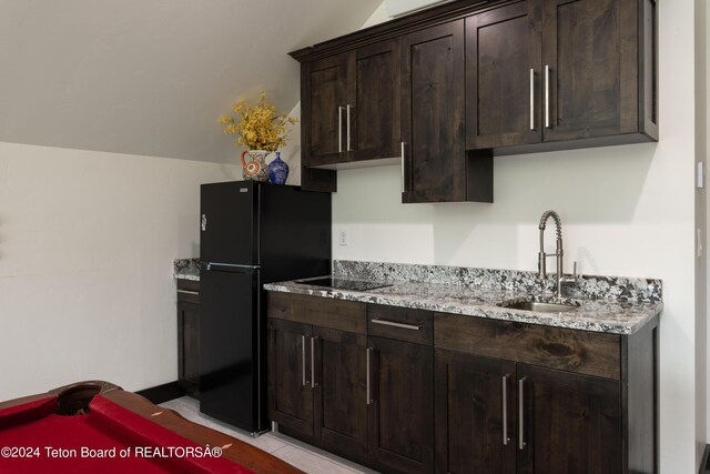 kitchen with vaulted ceiling, light stone countertops, black appliances, pool table, and sink