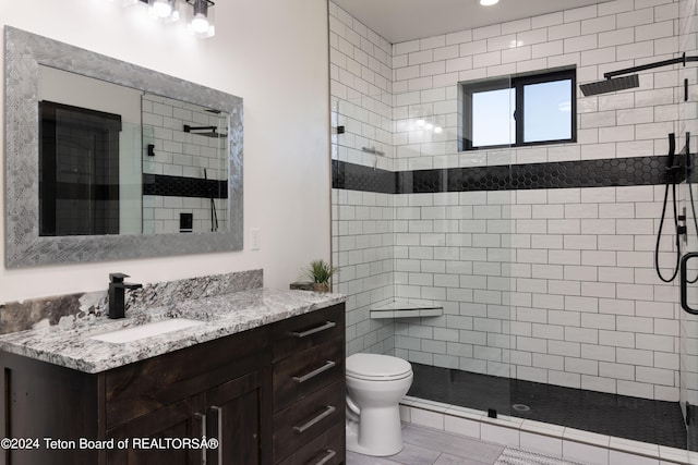 bathroom featuring tile patterned flooring, an enclosed shower, vanity, and toilet