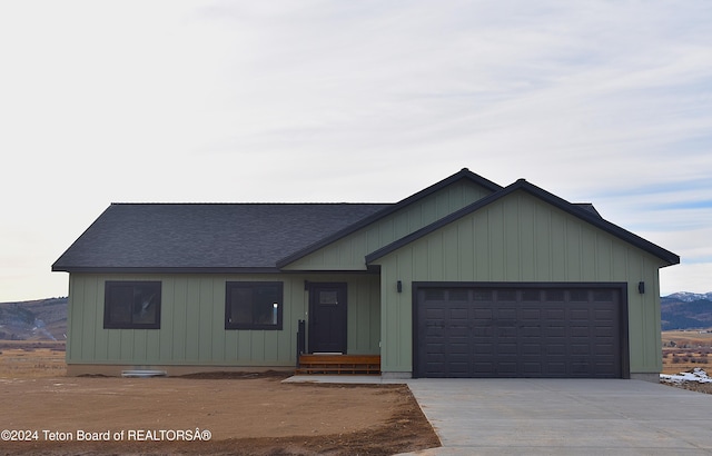 single story home featuring a mountain view and a garage