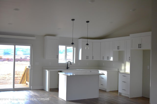 kitchen with a healthy amount of sunlight, white cabinetry, a center island, and pendant lighting