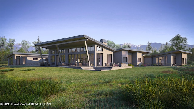 rear view of property featuring a mountain view, a yard, and a patio