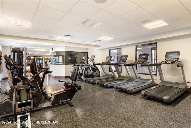 workout area featuring a healthy amount of sunlight and a drop ceiling