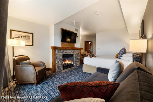 living room featuring carpet and a stone fireplace