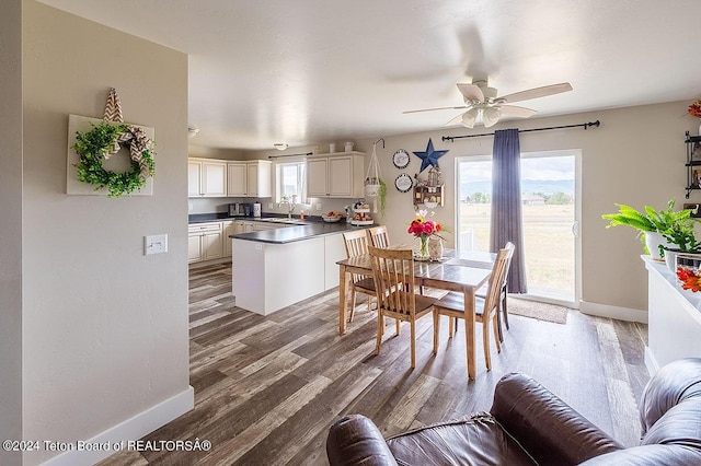 dining room with a ceiling fan, baseboards, and wood finished floors