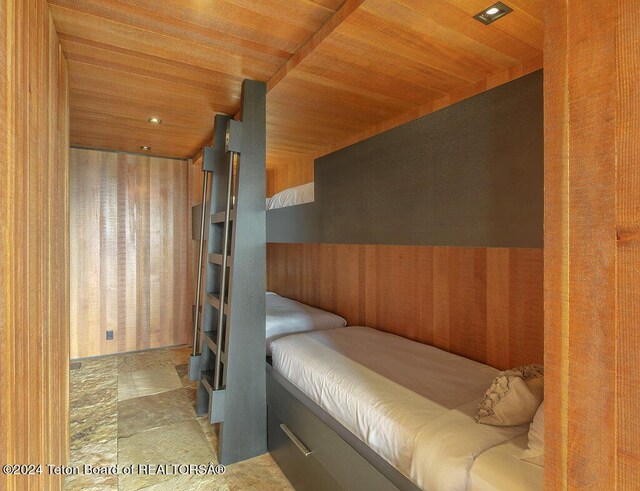 unfurnished bedroom featuring wood ceiling and wood walls