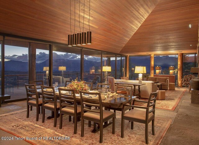 dining space featuring a mountain view, vaulted ceiling, and wooden ceiling