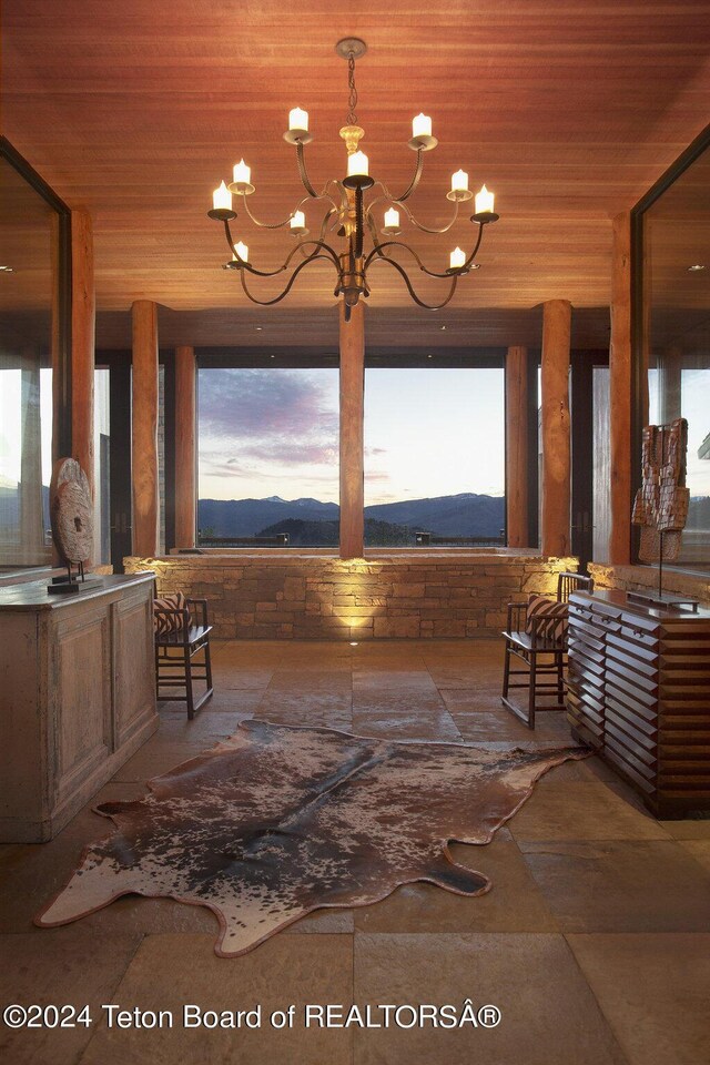 interior space featuring an inviting chandelier, a mountain view, and wood ceiling