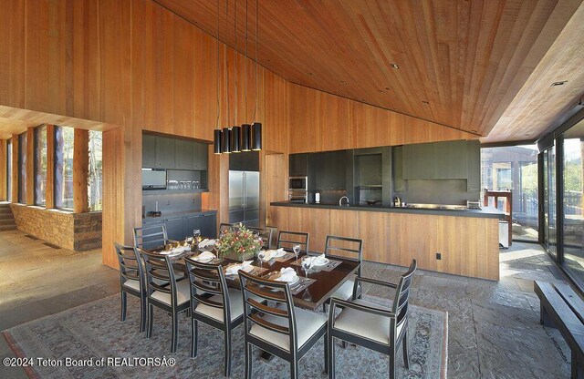 dining room featuring wooden walls, wooden ceiling, and high vaulted ceiling