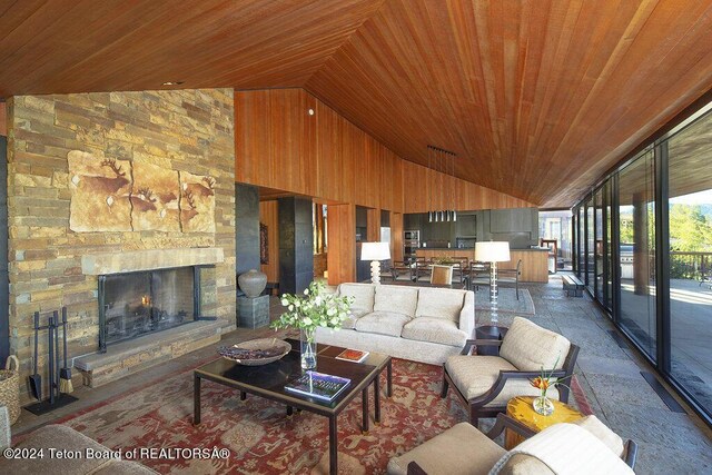 living room featuring high vaulted ceiling, a fireplace, wooden ceiling, and wooden walls